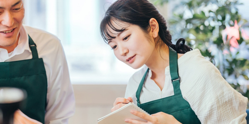 メモを取っている女性の店員