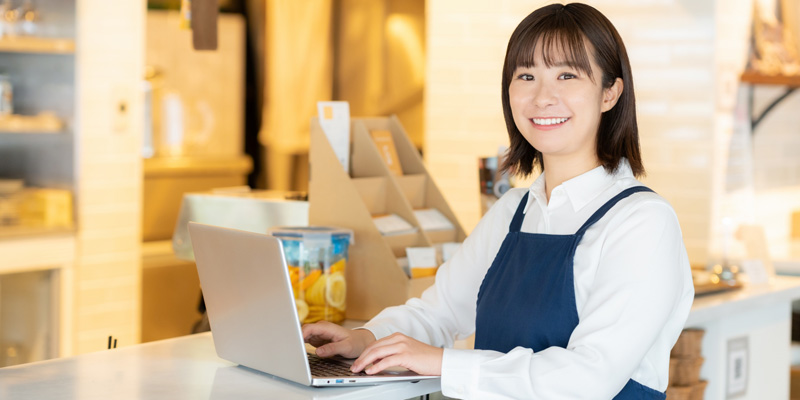 パソコンで作業をしている女性の店員