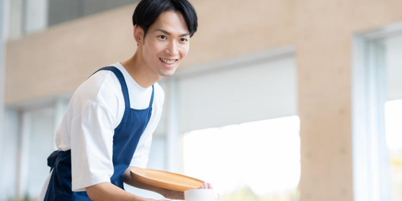 飲み物を渡しているホールスタッフの男性