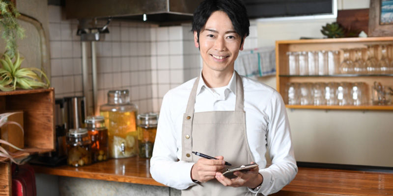 メモを取っている男性の飲食店スタッフ