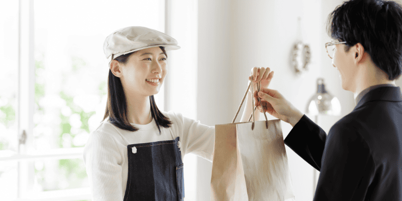 お客さんに商品を渡す店員