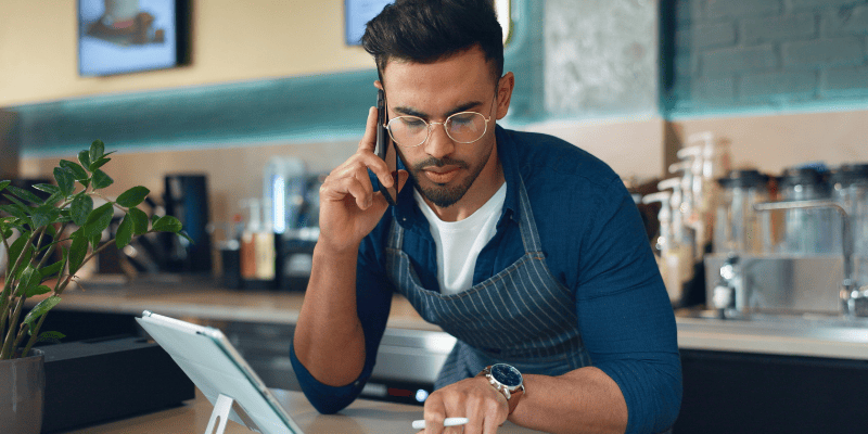 データを見ながら電話する店員