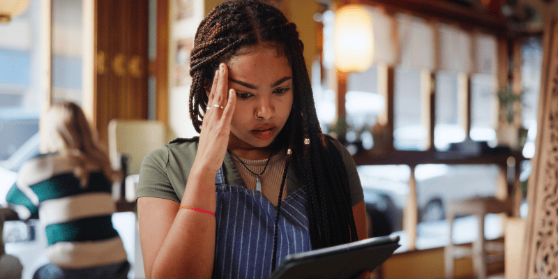 頭を抱える従業員の女性