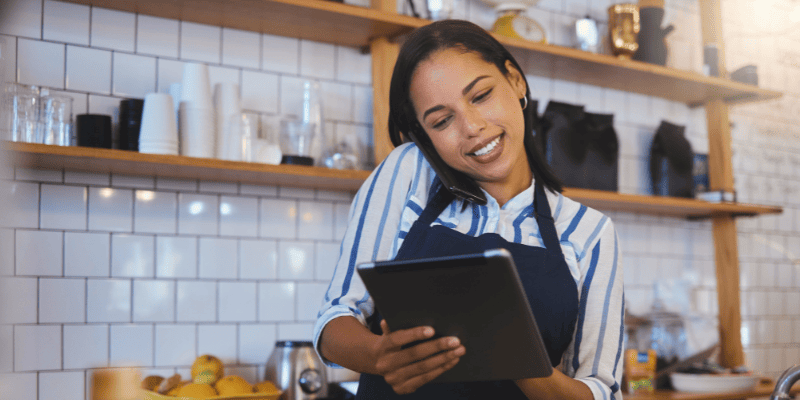 電話しながらタブレットを操作する飲食店のスタッフ