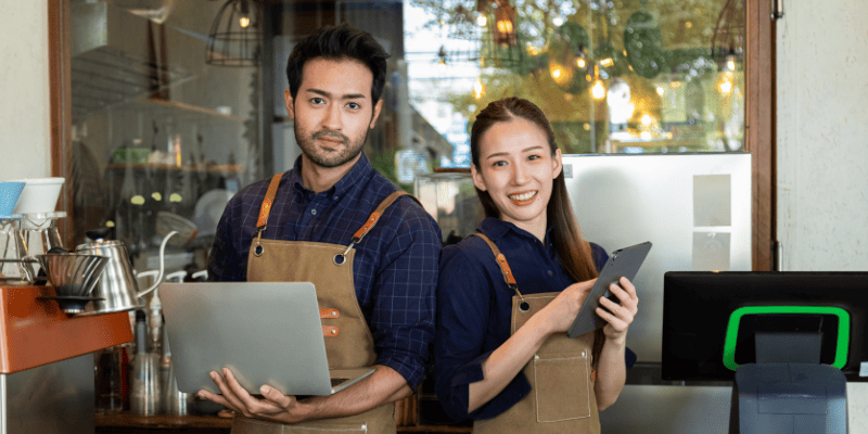 PCを持つ男性とタブレットを持つ女性スタッフ