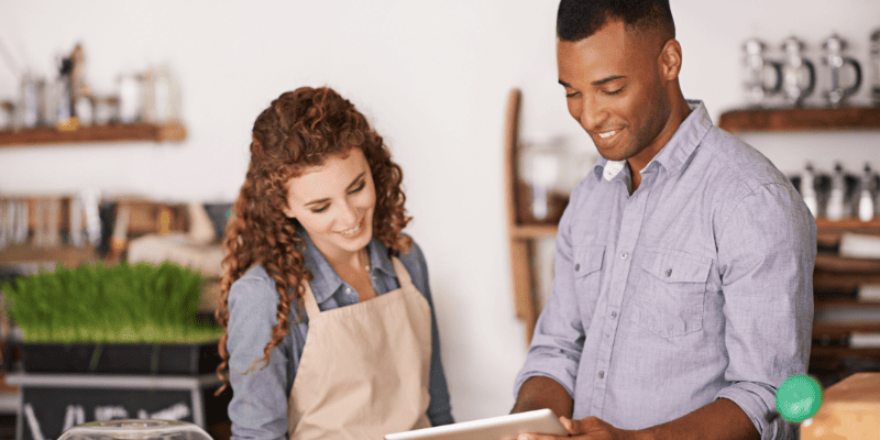 タブレットを見て笑顔で話し合う人たち