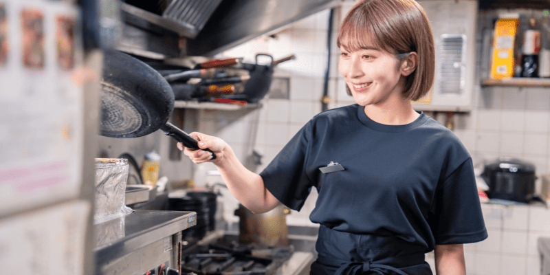 飲食店の厨房で働く女性