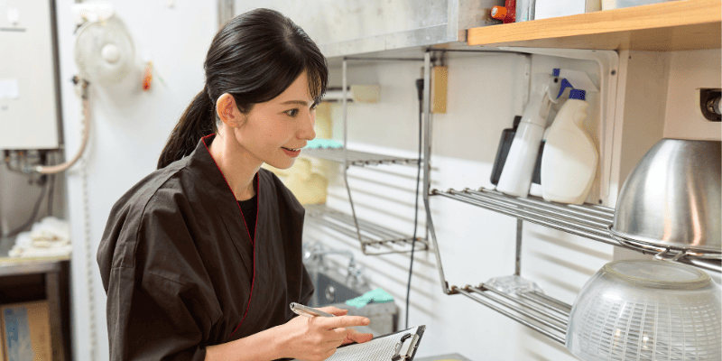 飲食店の洗い場をチェックする女性