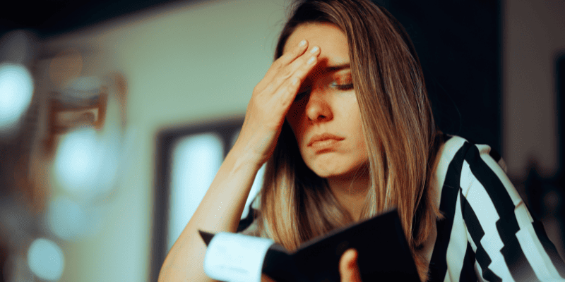 頭を抱えて伝票を見る女性