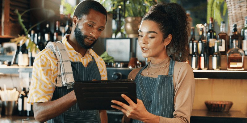 タブレットを持って話し合う飲食店スタッフたち