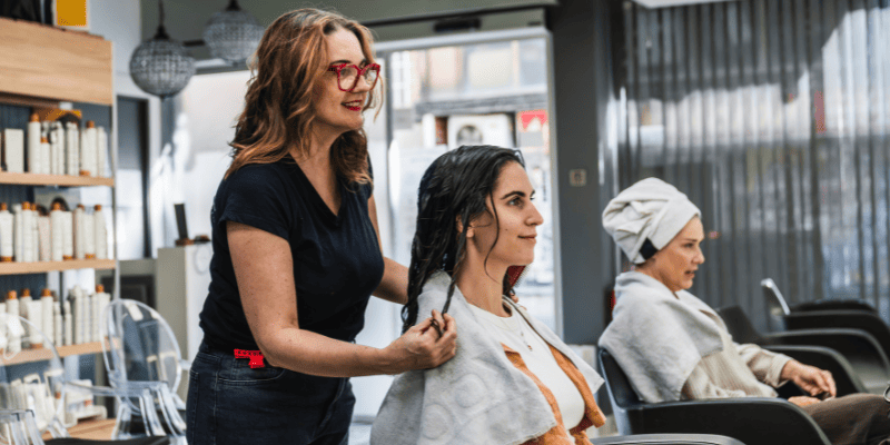 美容室で鏡を見るお客さんと店員