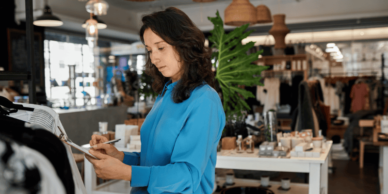 アパレルショップで書類を書く女性