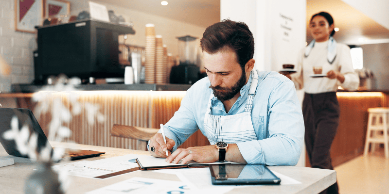 机の上で資料に字を書く飲食店従業員