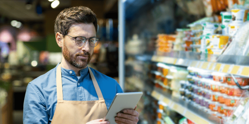 タブレットを操作するスーパーマーケットの従業員